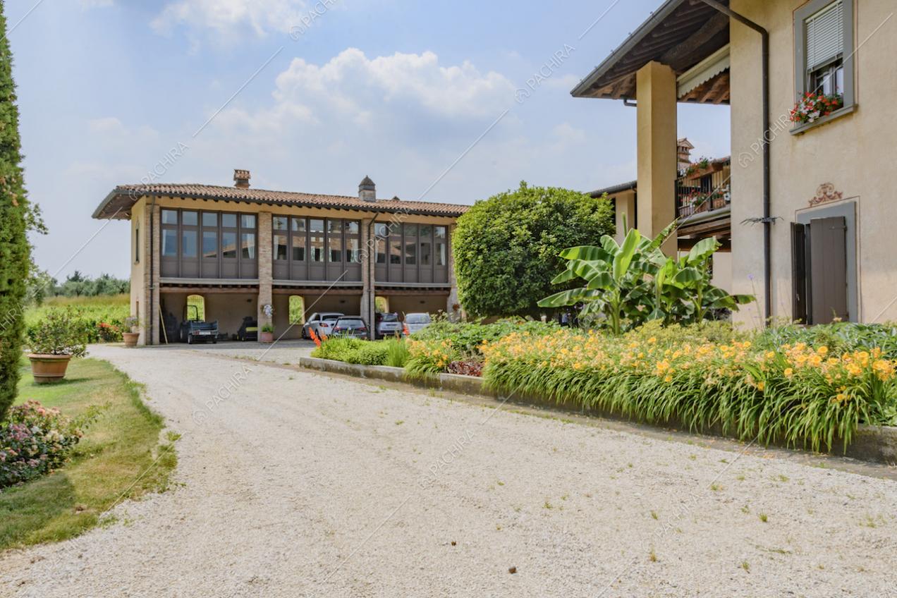 Viale d'accesso alla villa e corte con fiori e piante