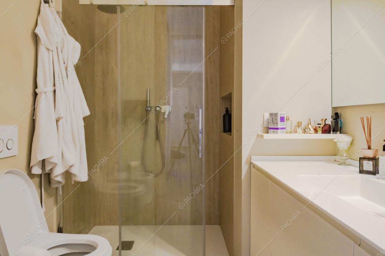 Bagno arredato con colori chiari e box doccia 