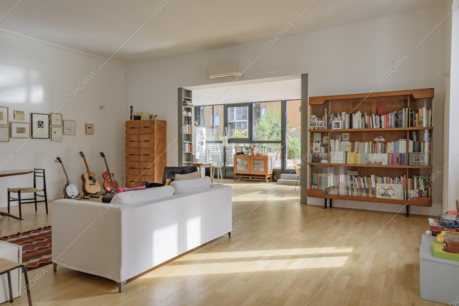 Soggiorno con pavimenti in parquet e ampie vetrate