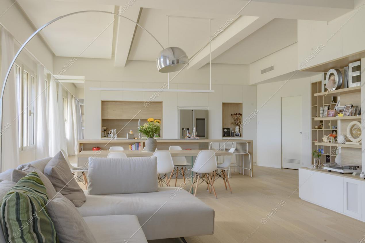 Zona giorno dai colori tenui con lampada ad arco di design