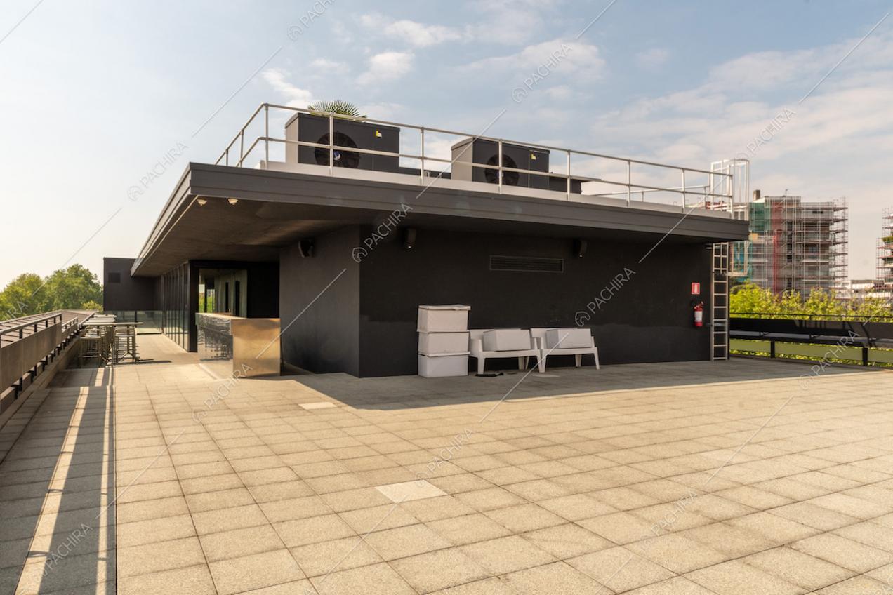 Ampia terrazza con vista su Milano e tavolini e sedie in metallo da esterno