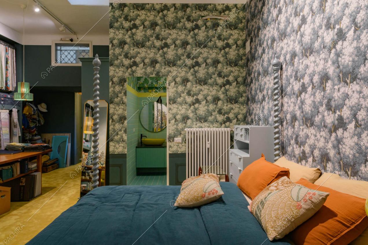 Camera da letto matrimoniale con bagno privato e carta da parati con alberi