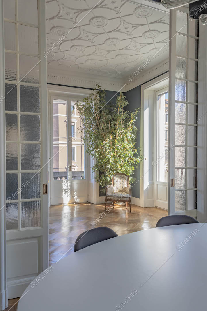 Dalla sala da pranzo vista sul soffitto con boiserie del luminoso salotto