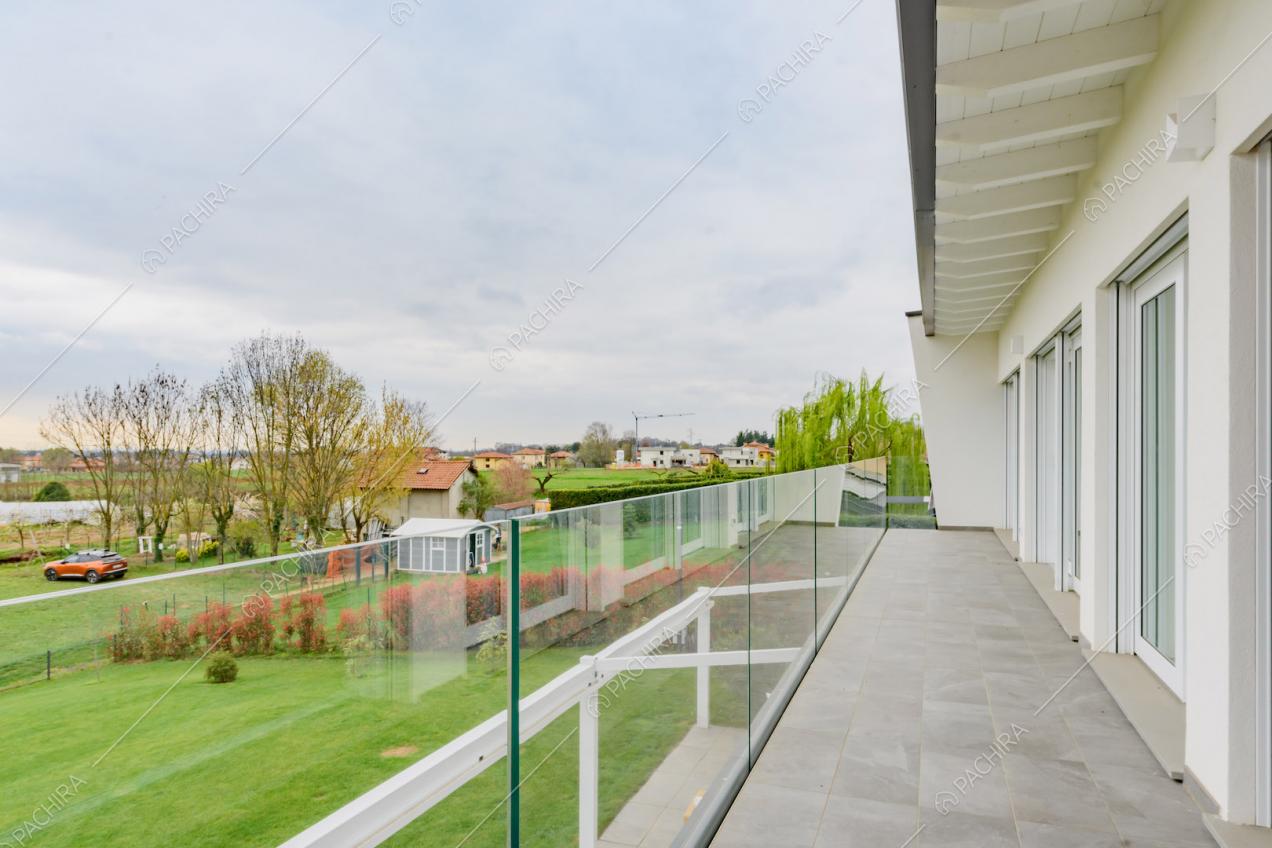 Terrazza con ringhiera in vetro e porte-finestre