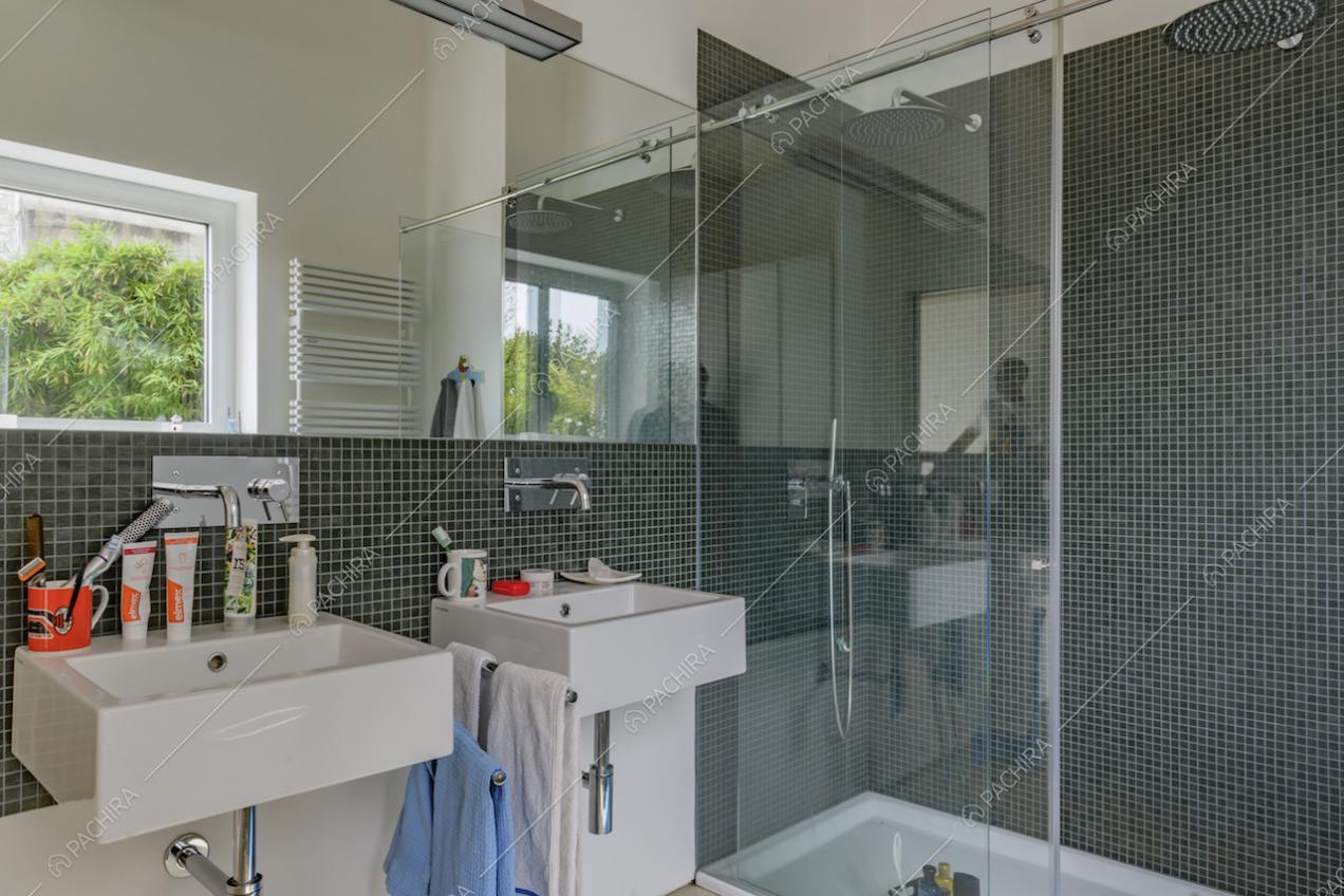 Doppio lavandino nel bagno con le pareti bianche e piccole piastrelle blu