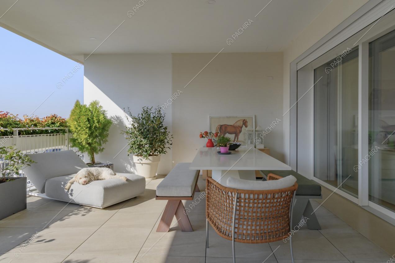 Ampia terrazza con tavolo da pranzo e divano da esterno