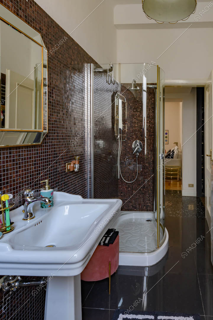 Bagno con pareti in piccole piastrelle a mosaico sulle nuances del marrone