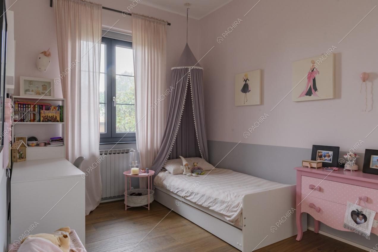 Letto singolo e mobile rosa con cassetti nella cameretta