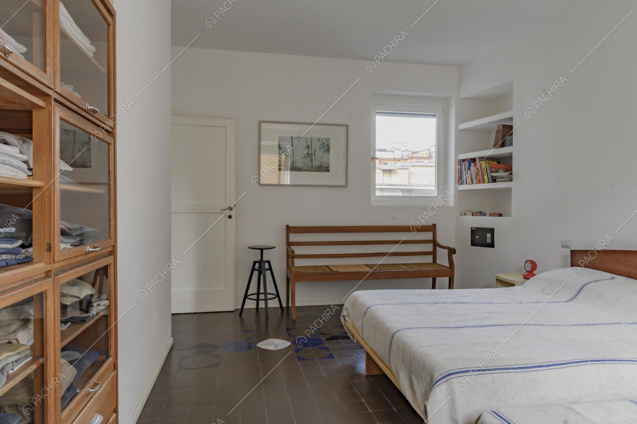 Camera da letto con piastrelle d'epoca e panca in legno