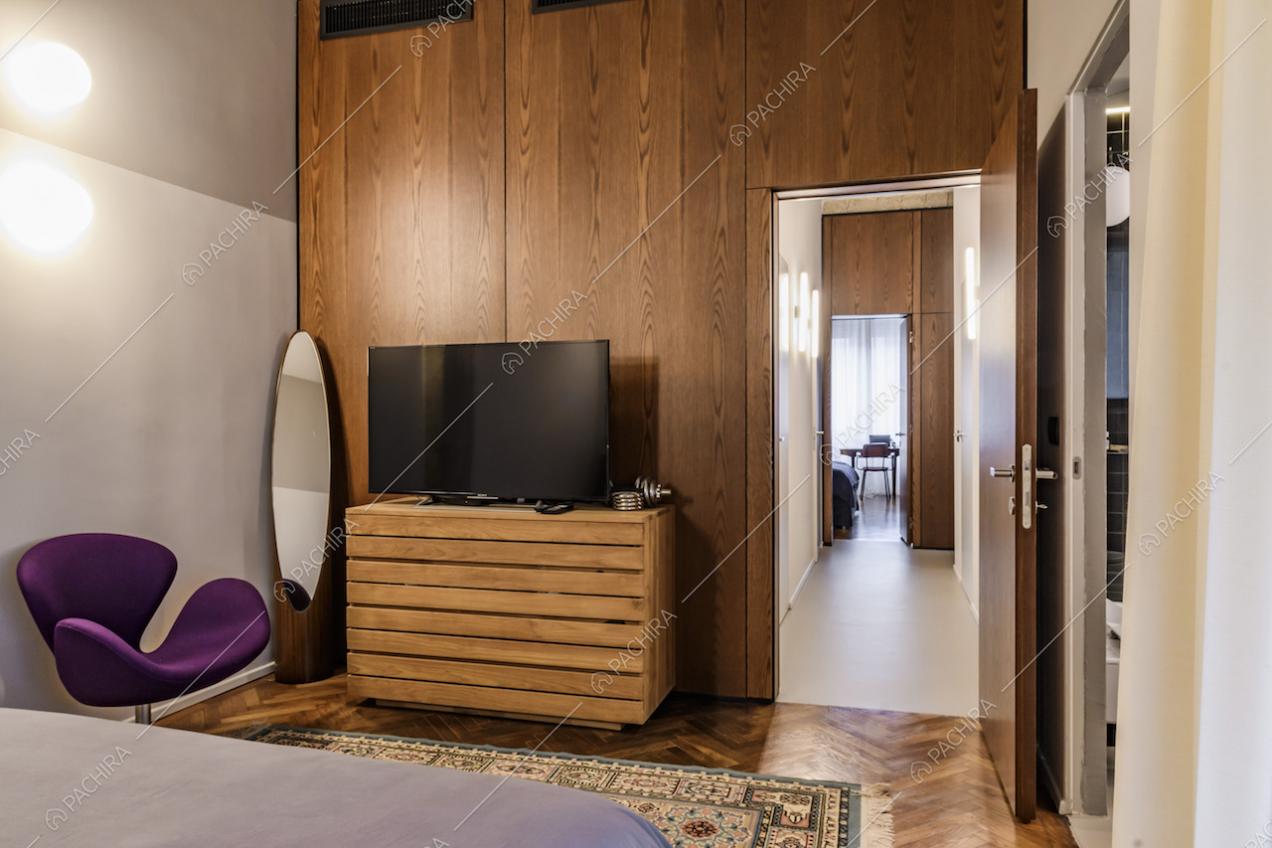 Camera da letto con parquet e pareti in legno