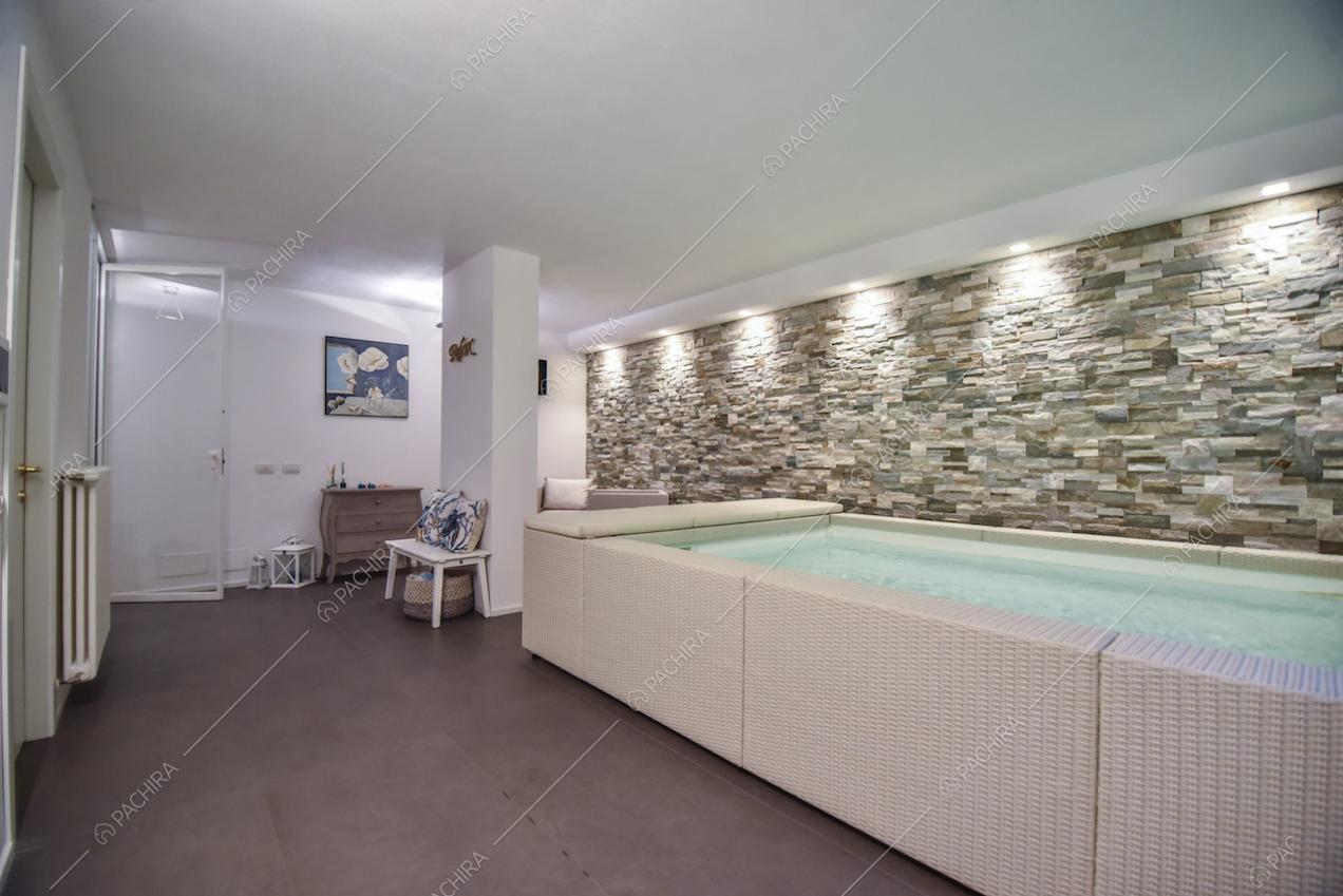 Grande vasca da bagno all'interno della villa e parete in pietra