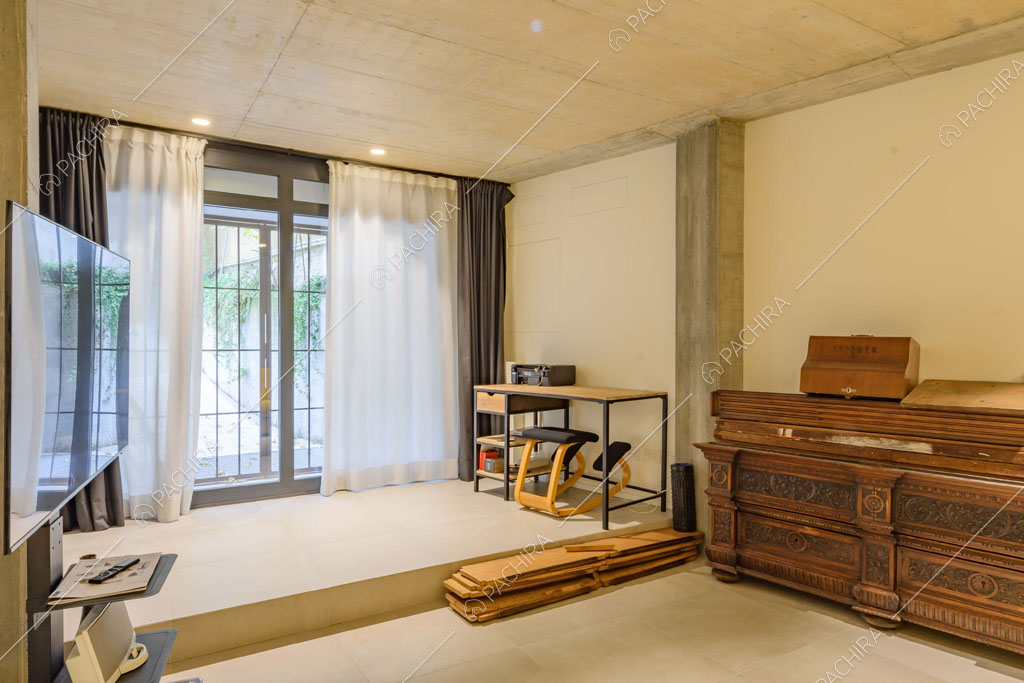 Luminosa stanza con soffitto in cemento e credenza antica