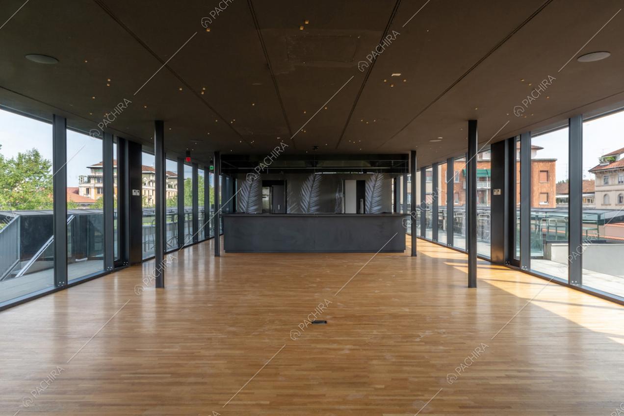 Salone con pavimento in parquet, bancone da bar nero, con carta da parati, e vista sulla terrazza