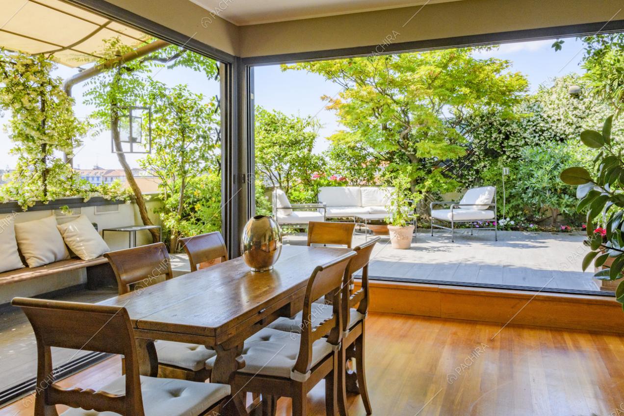 Tavolo da pranzo circondato da vetrate con vista sul terrazzo